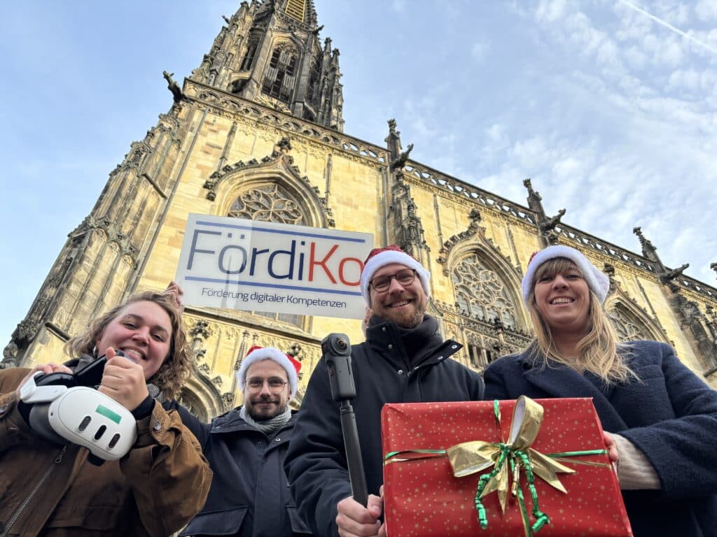 4 Personen in Münster halten technische Ausrüstung in die Kamera